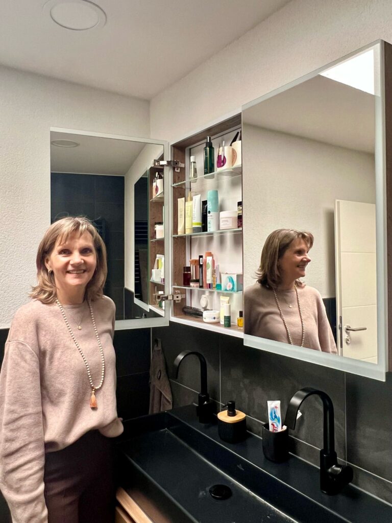Bild von Monika Köhler vor einem aufgeräumten Badezimmerschrank